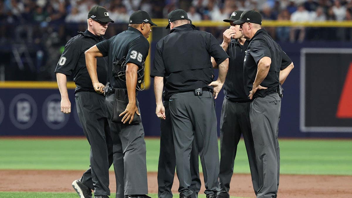 Officiating crew members talk on the field at Tropicana Field.