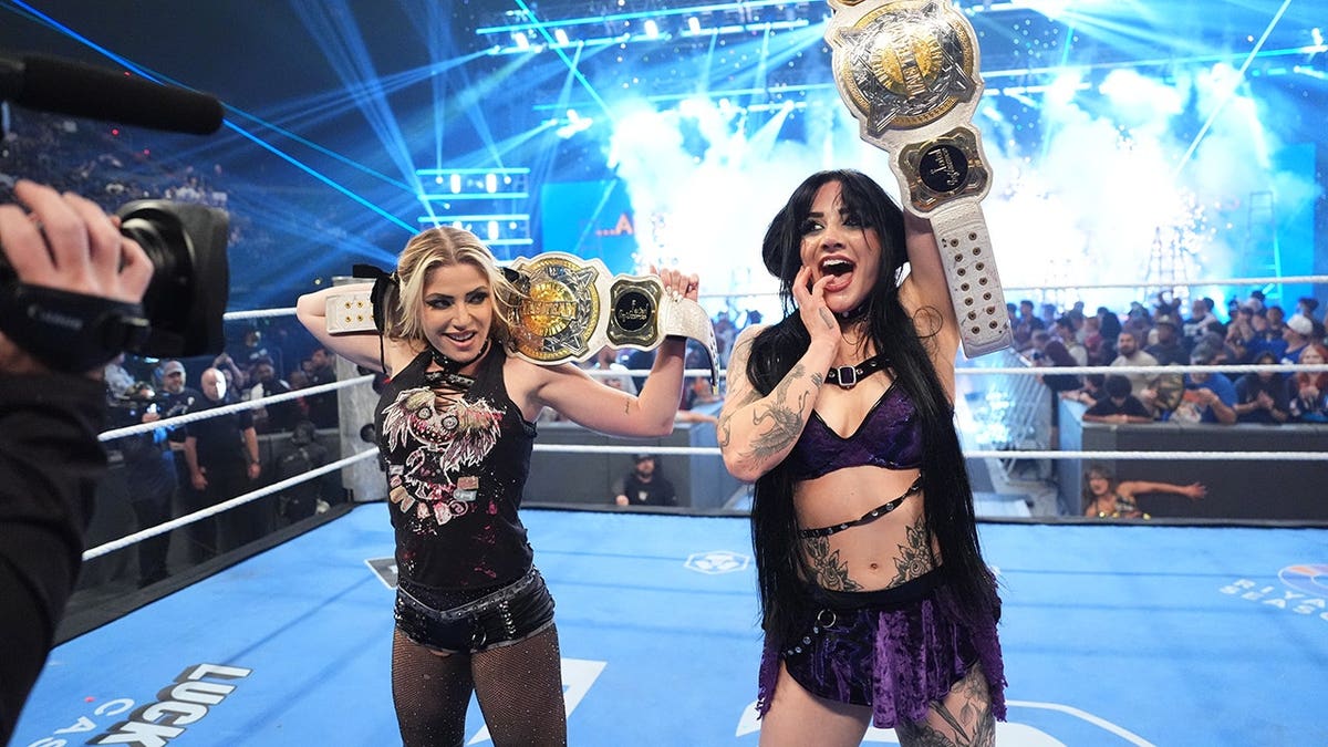Alexa Bliss and Tatum Paxley hold WWE Women's Tag Team Championship belts.