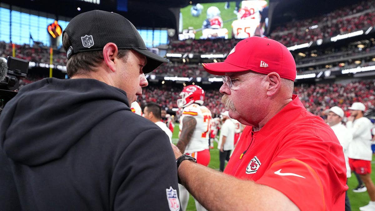 Andy Reid greets Klint Kubiak on the field at Allegiant Stadium.