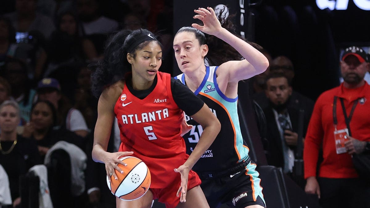 Angel Reese dribbles the basketball against Breanna Stewart during a WNBA playoff game.