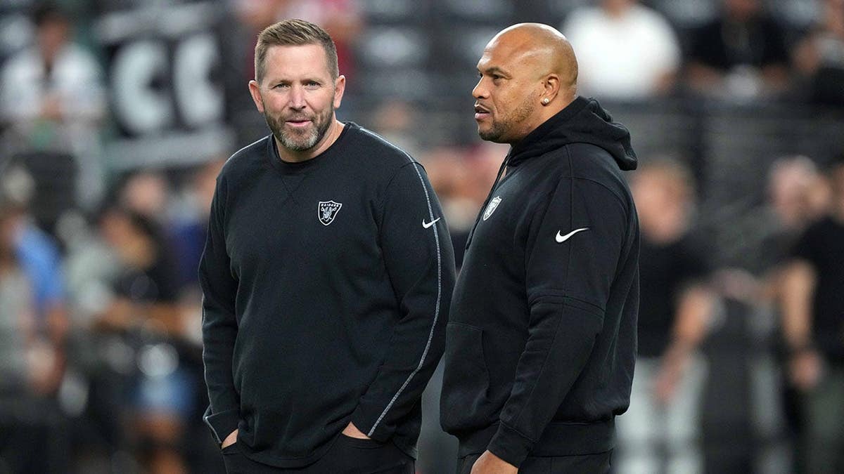 Las Vegas Raiders coach Antonio Pierce and pass game coordinator Scott Turner stand during a game.