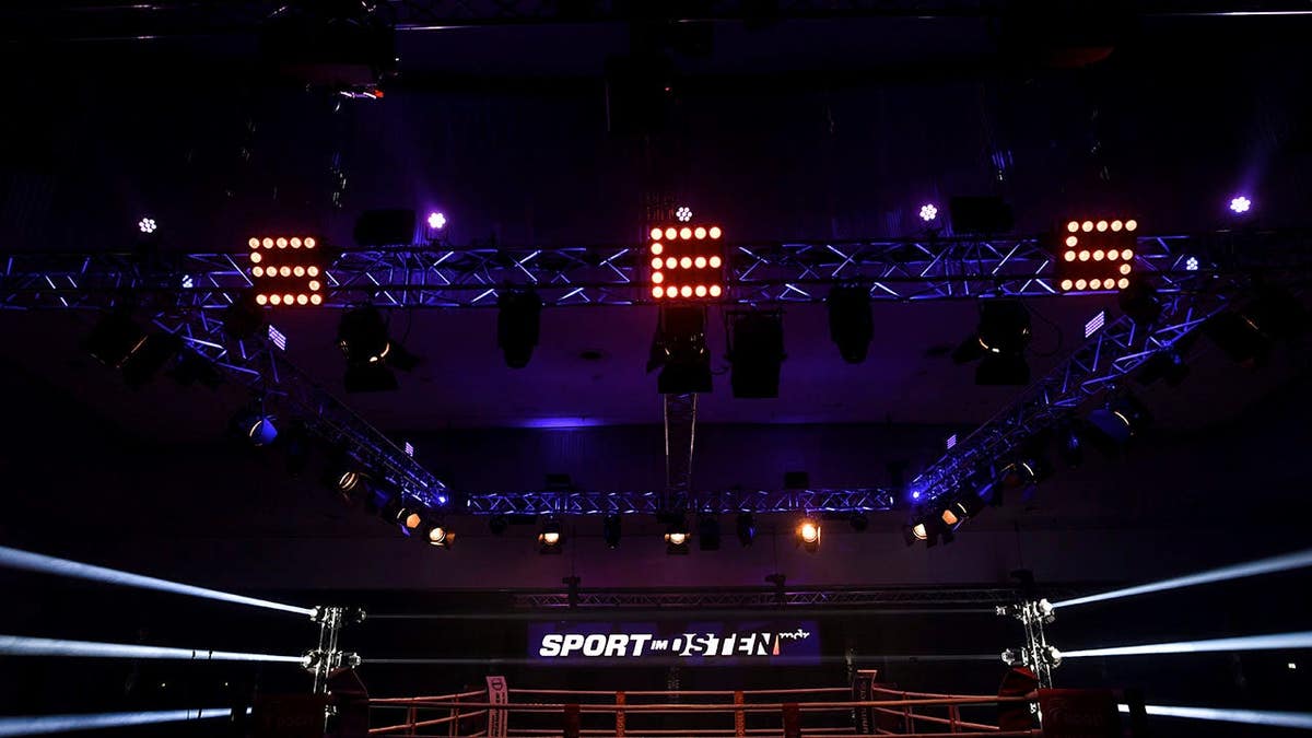 Artur Henrik and Krisztian Santa prepare for a middleweight boxing match in the ring.