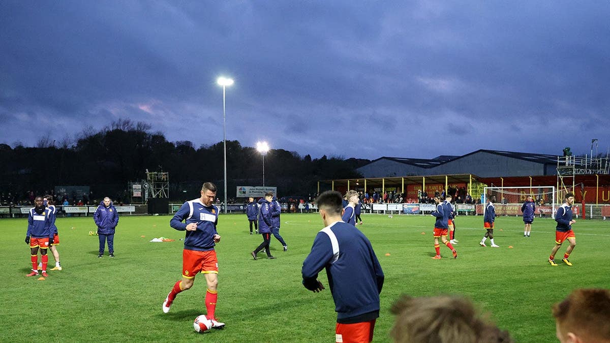 Banbury players warm up on the field before an Emirates FA Cup match.
