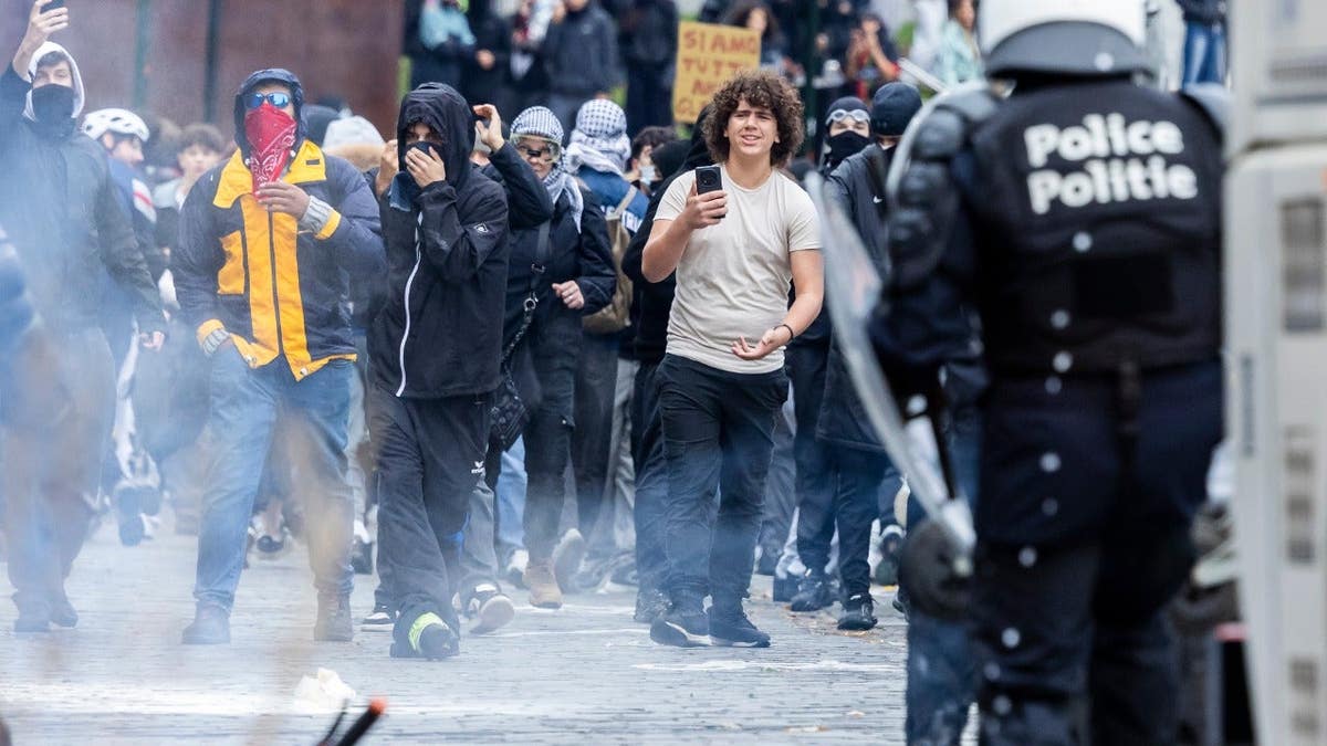 Protesters clash with riot police during a national demonstration in Brussels