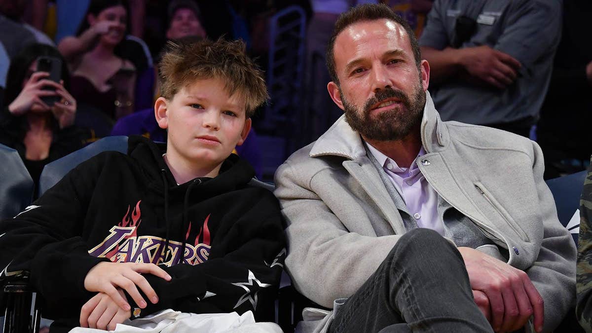 Ben Affleck and Samuel Garner Affleck seated at a basketball game.
