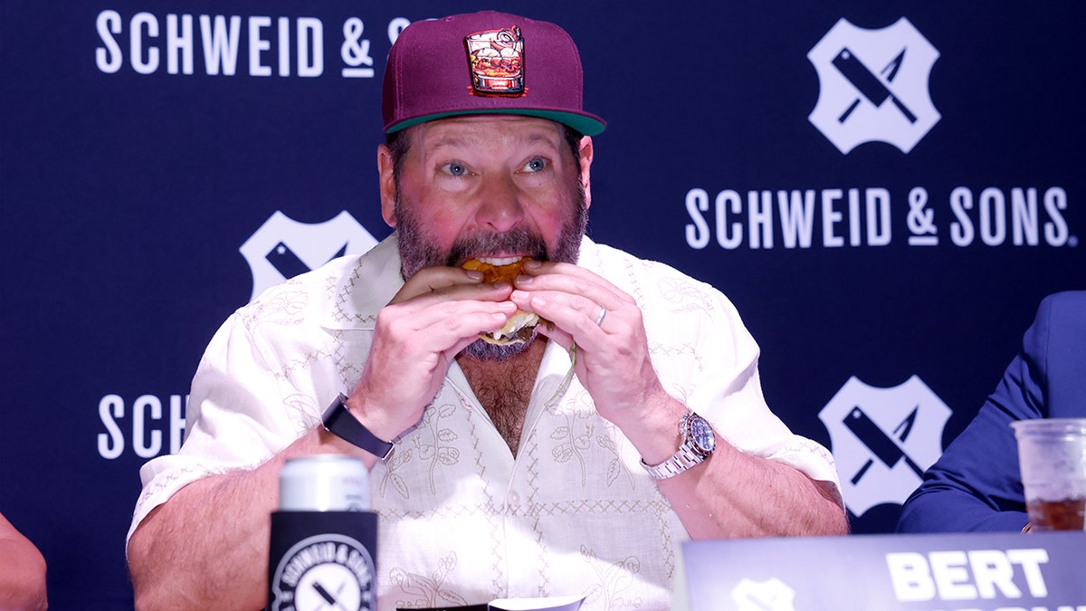 Bert Kreischer bites into a burger.