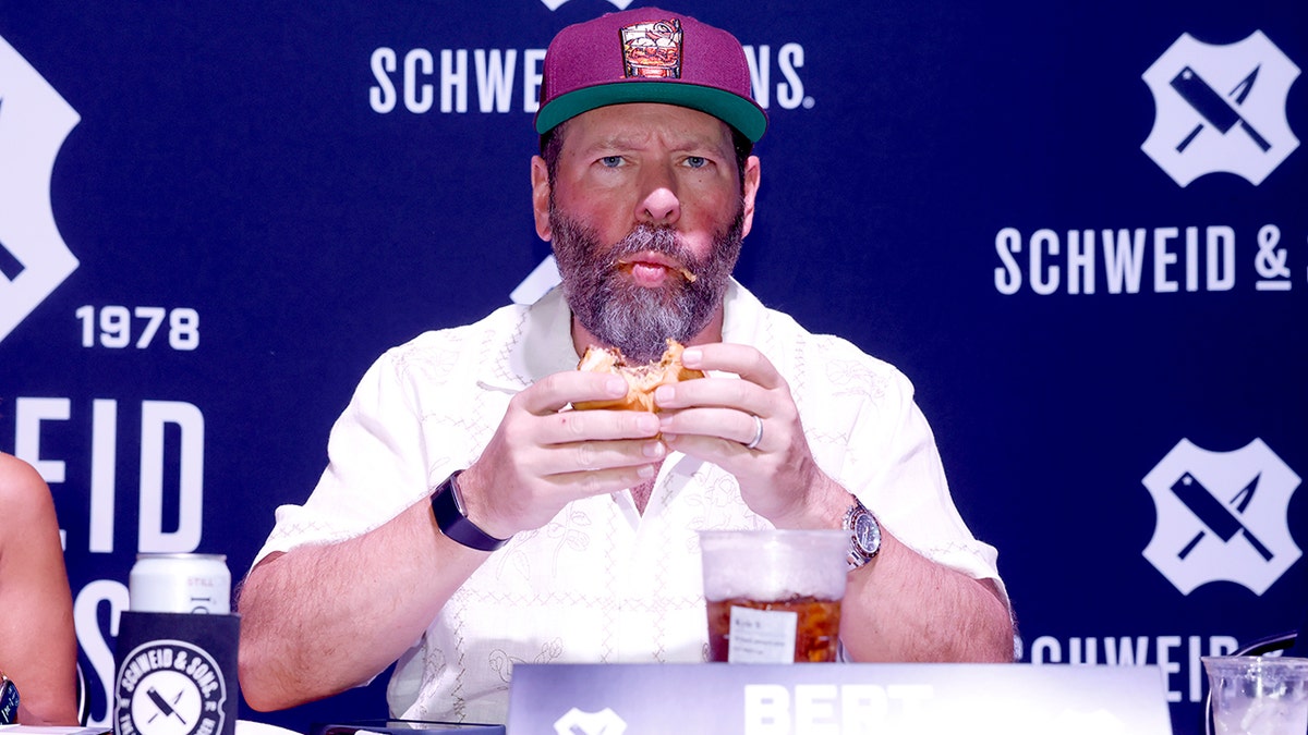 Bert Kreischer makes a weird face while eating a burger.