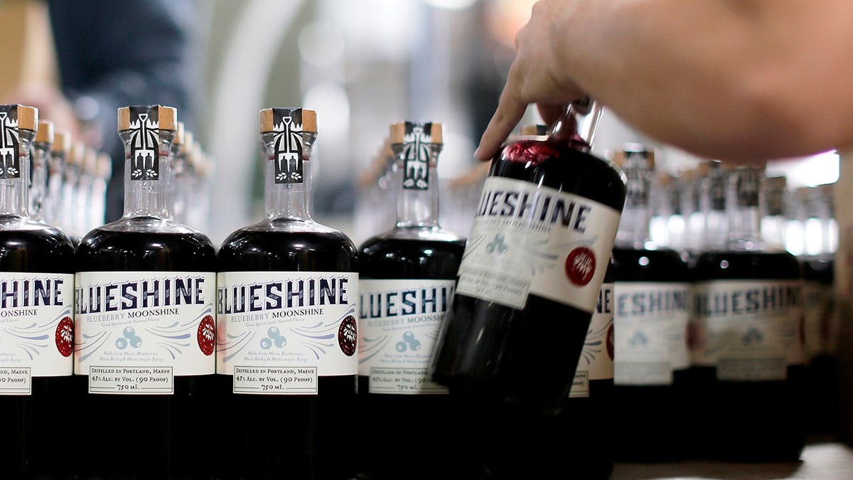 Seth Powers boxes bottles of blueberry moonshine at Maine Craft Distilling.