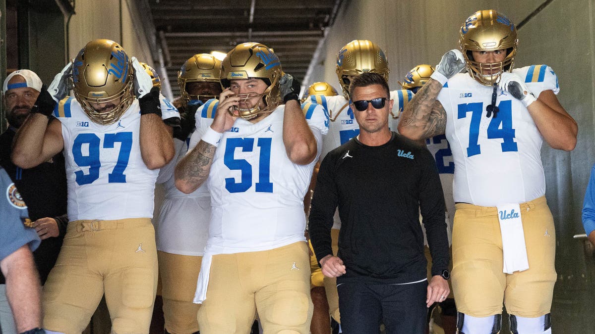 Bob Chesney leads the UCLA Bruins onto the field at Autzen Stadium.