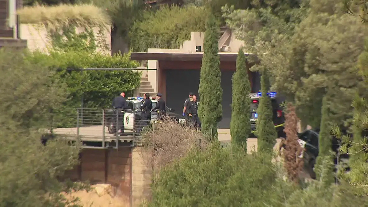 Police officers and patrol vehicles outside a hillside home in Oakland, California