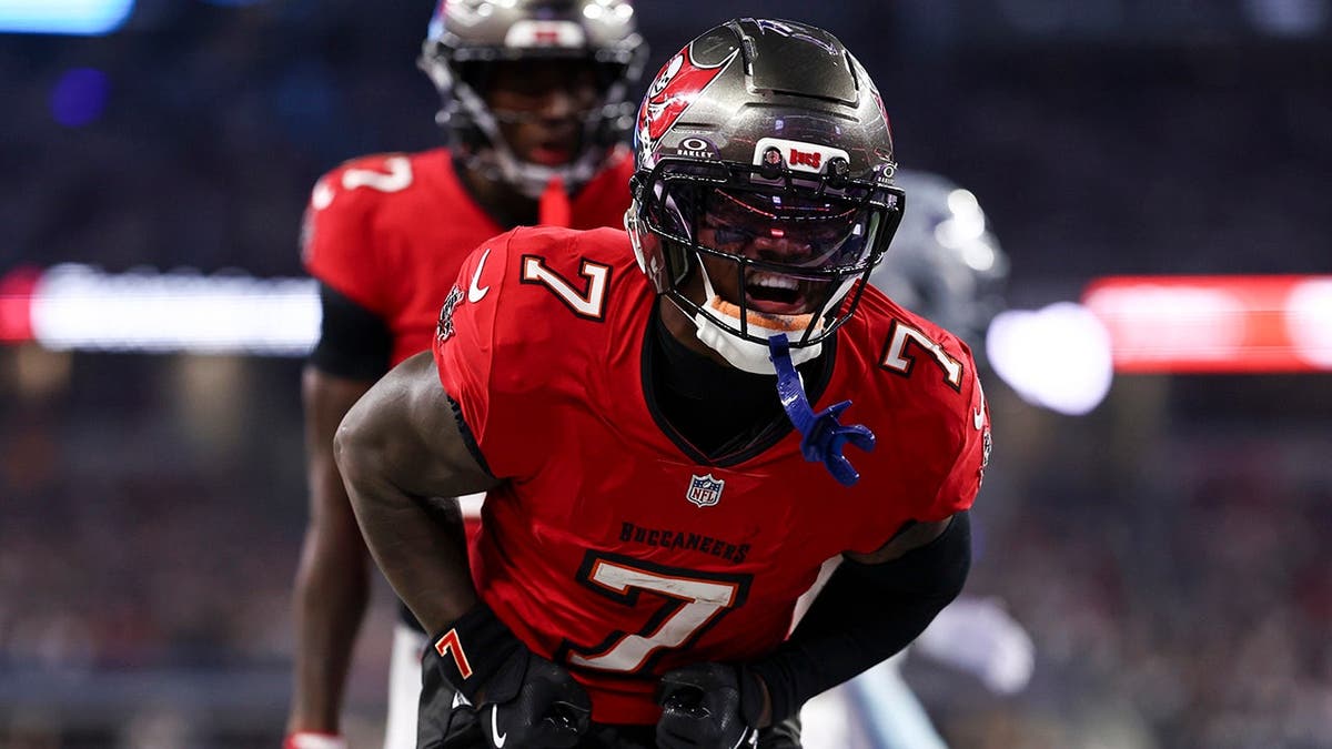 Bucky Irving #7 celebrates after scoring a touchdown during an NFL game.