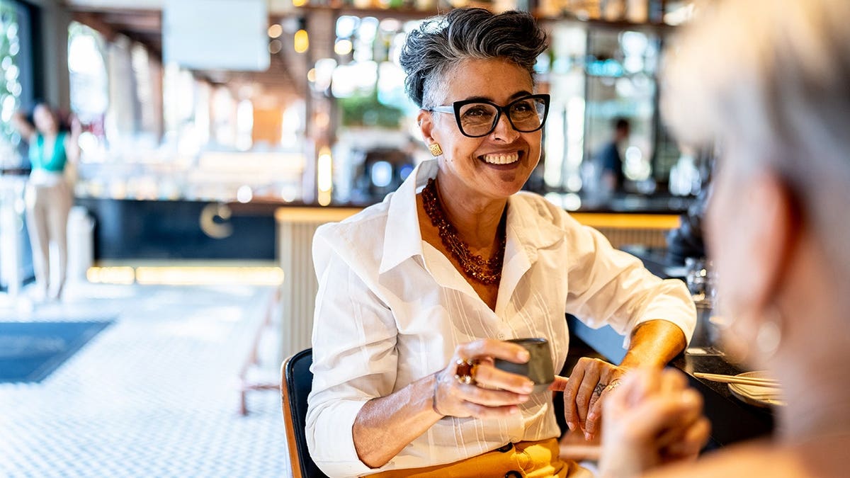 Businesswoman talks with coworker in Japanese restaurant.