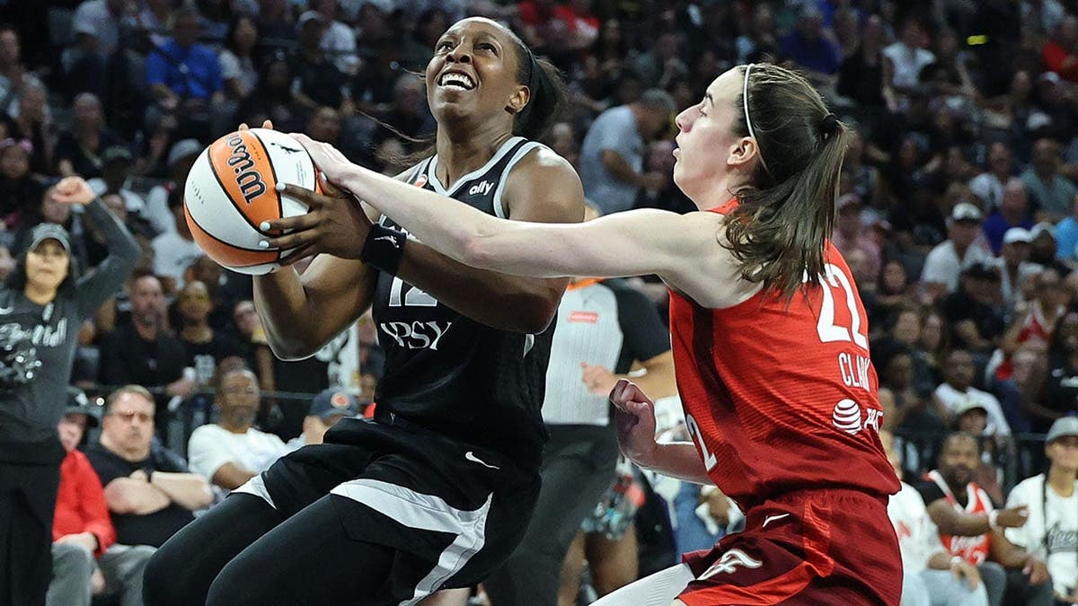 Caitlin Clark #22 knocks the ball away from Chelsea Gray #12 on a breakaway.