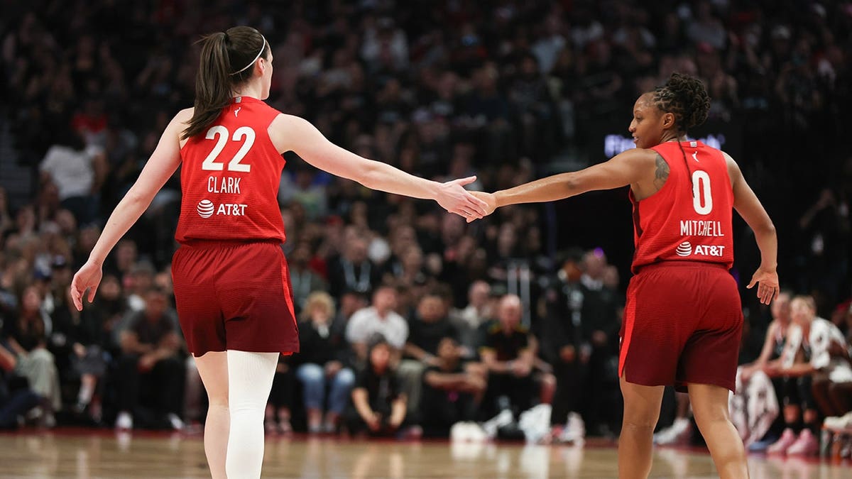 Caitlin Clark high-fives Kelsey Mitchell during an Indiana Fever game in Portland.