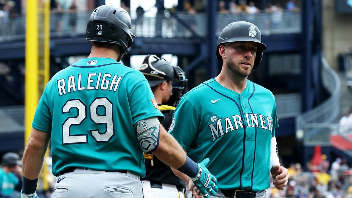 Cal Raleigh greets Mitch Garver crossing home plate at PNC Park.