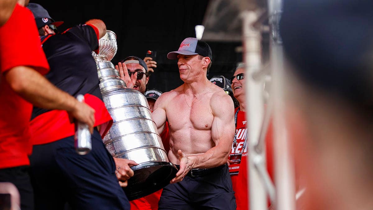 Carolina Hurricanes players rip Head Coach Rod Brind'Amour's shirt during Stanley Cup victory parade in Raleigh.