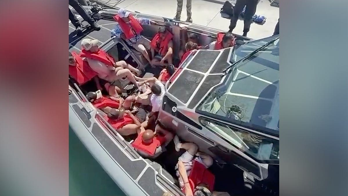 A group wearing life jackets sits aboard a CBP vessel after an interception near Newport Beach, California.