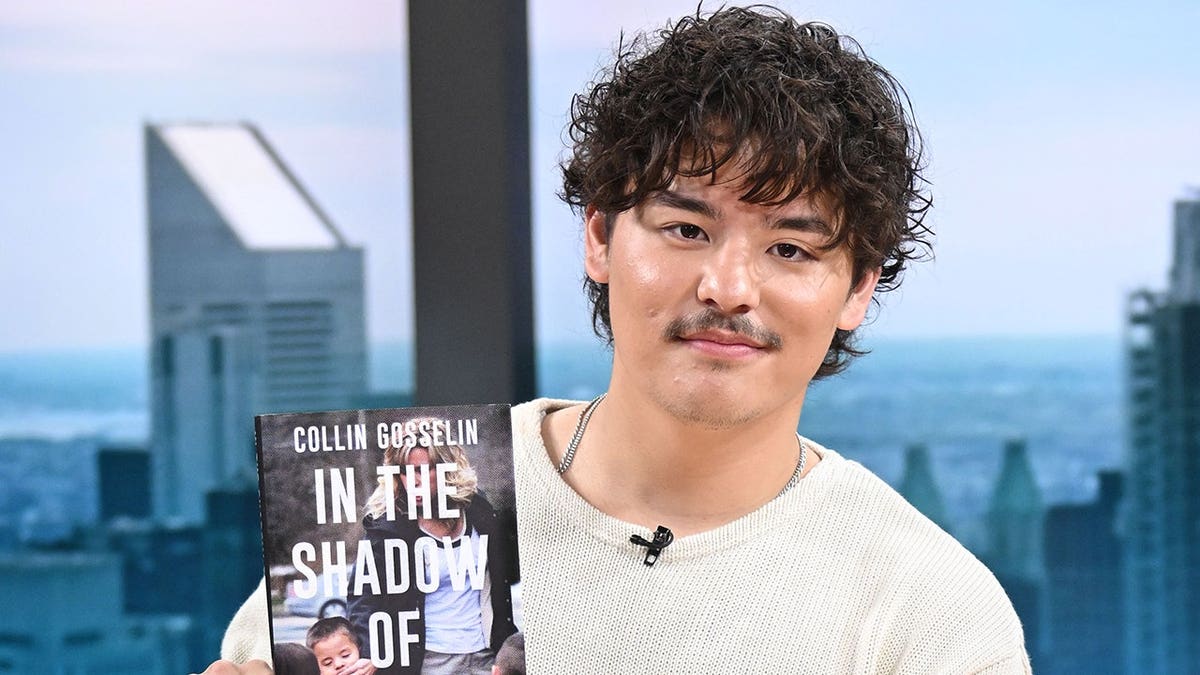 Collin Gosselin holds up a copy of his memoir