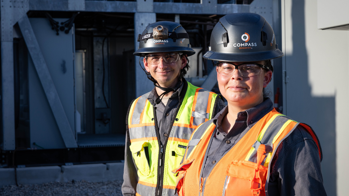 Compass Datacenters operators Michale Carvalho and Crystal Conroy stand in front of a hybrid cooling unit that can utilize either liquid or air cooling in Red Oak, Thursday, Aug. 27, 2026.