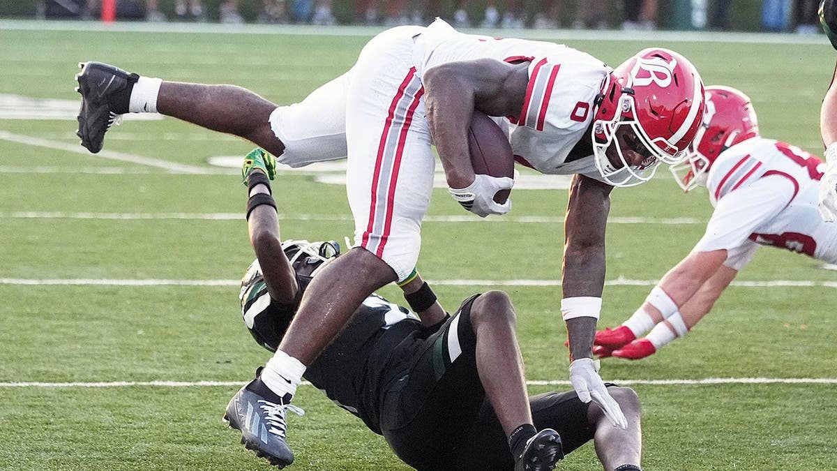 David Gabriel-Georges is tackled by Trinity defenders during a football game.