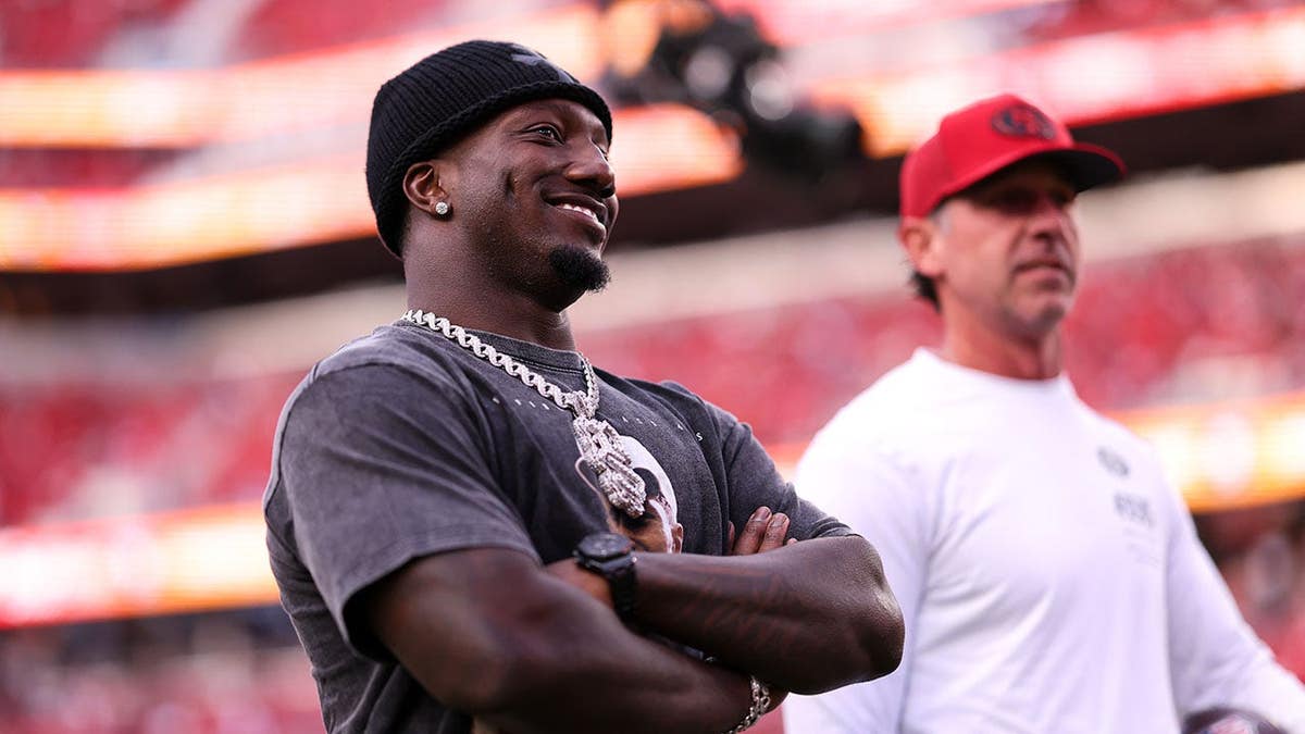 Deebo Samuel Sr. and Kyle Shanahan look on before a game at Levi's Stadium.