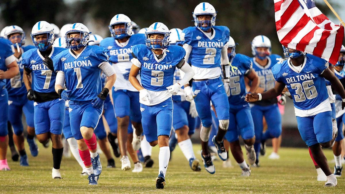 Deltona Wolves run onto the field before a game at Deltona High School.