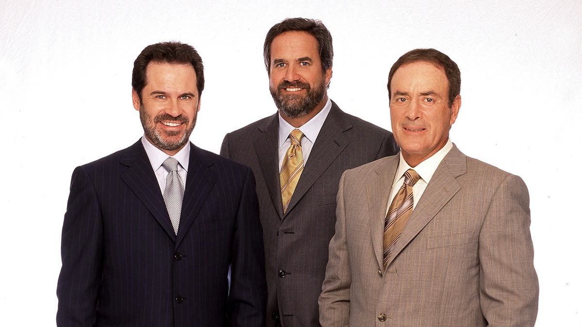 Dennis Miller, Dan Fouts and Al Michaels stand together at a studio set.