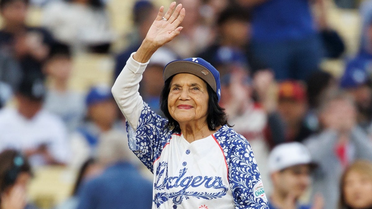 Dolores Huerta waves to fans at Dodger Stadium.