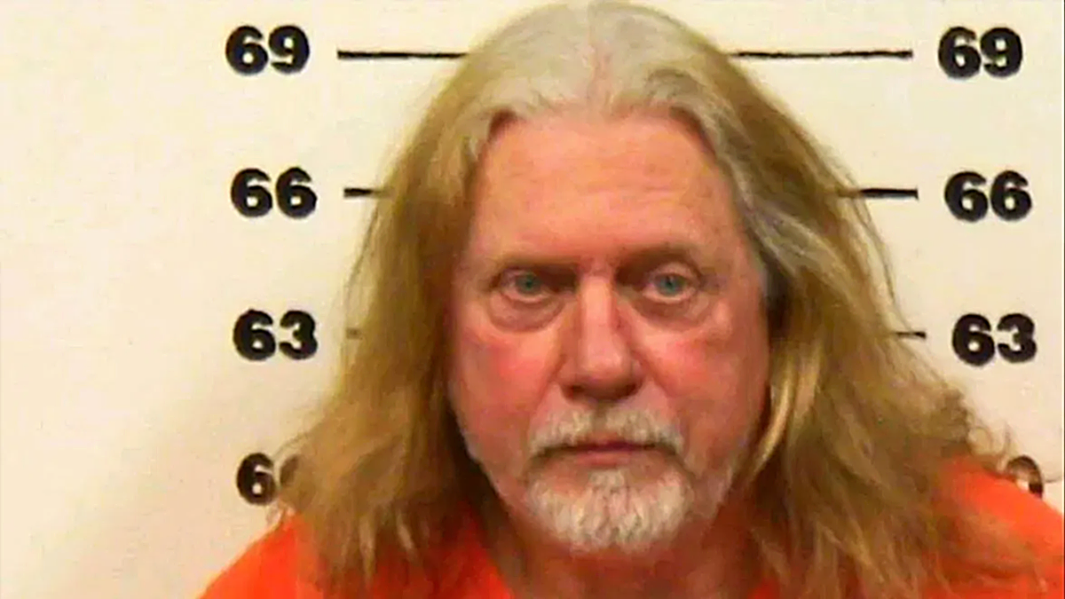 Don Wells mugshot, with long white hair and a short beard
