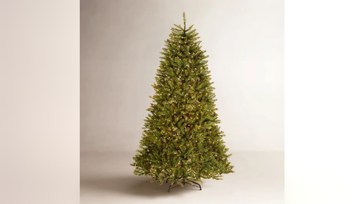 This full, pre-lit artificial tree becomes centerpiece of any room.