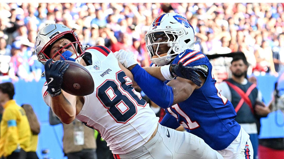 Efton Chism III catches a touchdown pass as Davison Igbinosun defends during an NFL game.