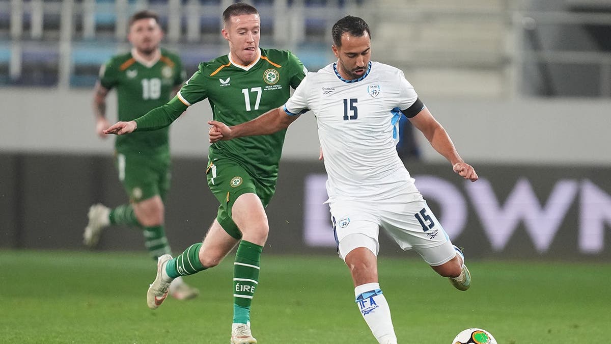 Eliel Peretz passes the ball in front of Jack Moylan during a UEFA Nations League soccer match.