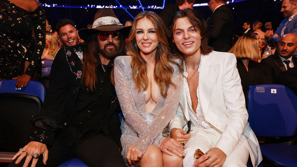 Billy Ray Cyrus, Elizabeth Hurley and Damian Hurley stand together at The O2 Arena in London.