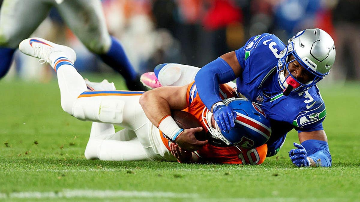 Nick Emmanwori of the Seattle Seahawks sacks Bo Nix of the Denver Broncos.