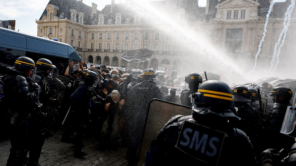 Riot police deploy a water cannon facing students during a protest in Rennes, France.