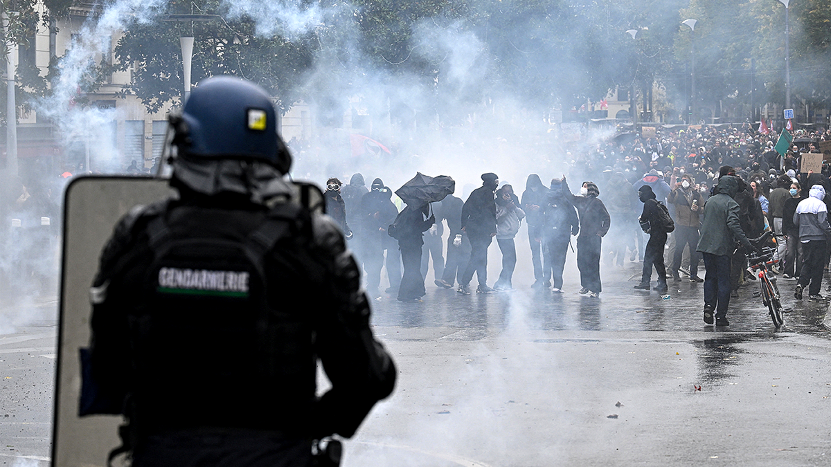 French gendarme stands amid tear gas during protests in Nantes.