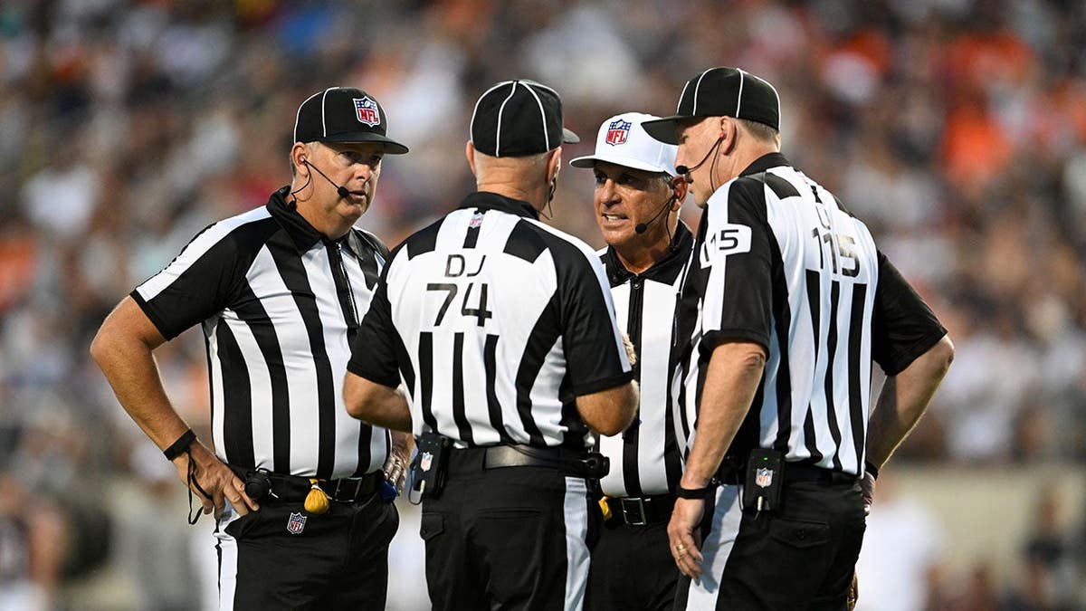 Game officials Jeff Seeman, John Hussey, Tony Michalek and Derrick Bowers talk on the field during the Pro Football Hall of Fame Game.