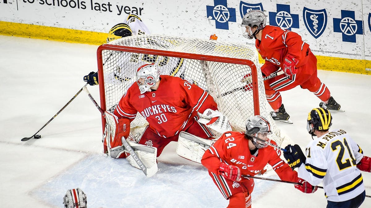 Garrett Van Wyhe attempts a wraparound shot on goaltender Sean Romeo during a Michigan Wolverines hockey game.