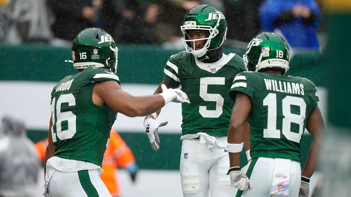 Garrett Wilson celebrates with teammates Kenyon Sadiq and Isaiah Williams after catching a touchdown pass.