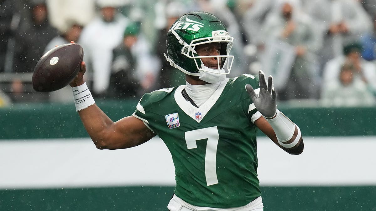 Geno Smith, wearing Jets uniform number 7, throws a pass during an NFL game.