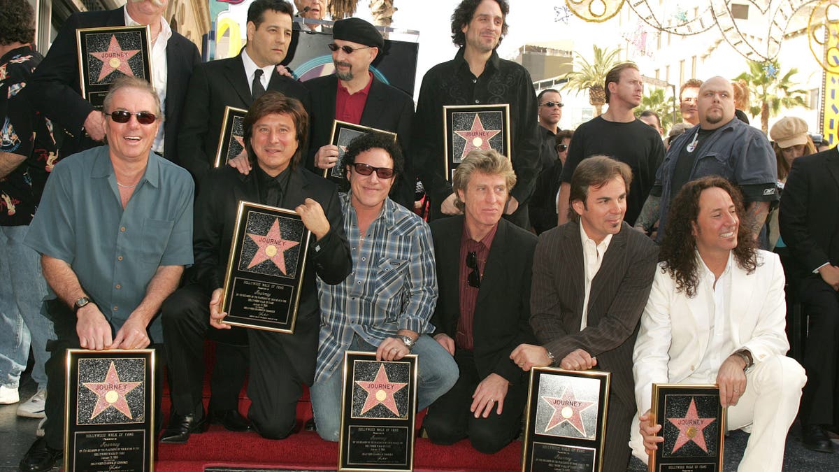 Members of Journey pose for a photo on the Hollywood Walk of Fame