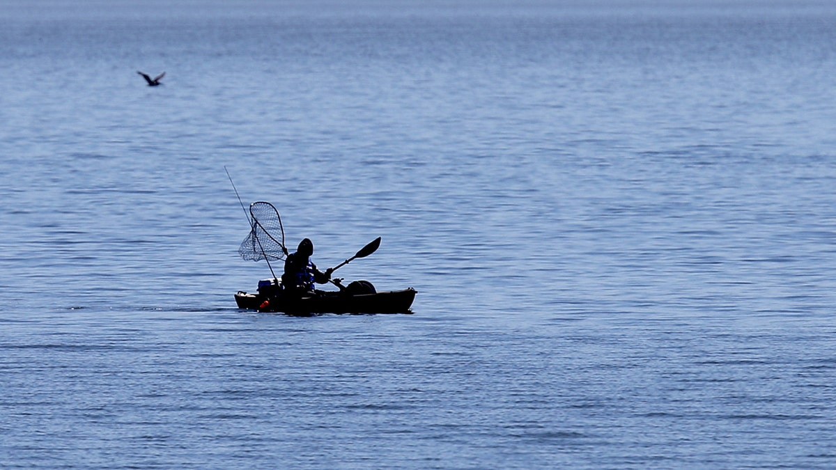 kayaker on beach fishing