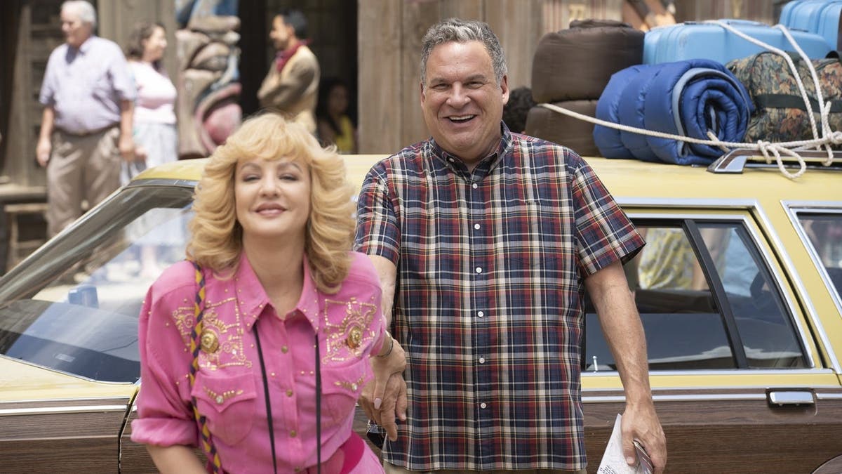 Wendi McLendon-Covey and Jeff Garlin stand together in a scene from The Goldbergs.