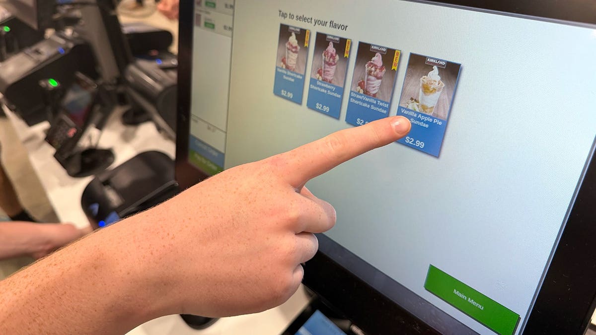 A hand pointing to a sundae at the Costco food court ordering kiosk