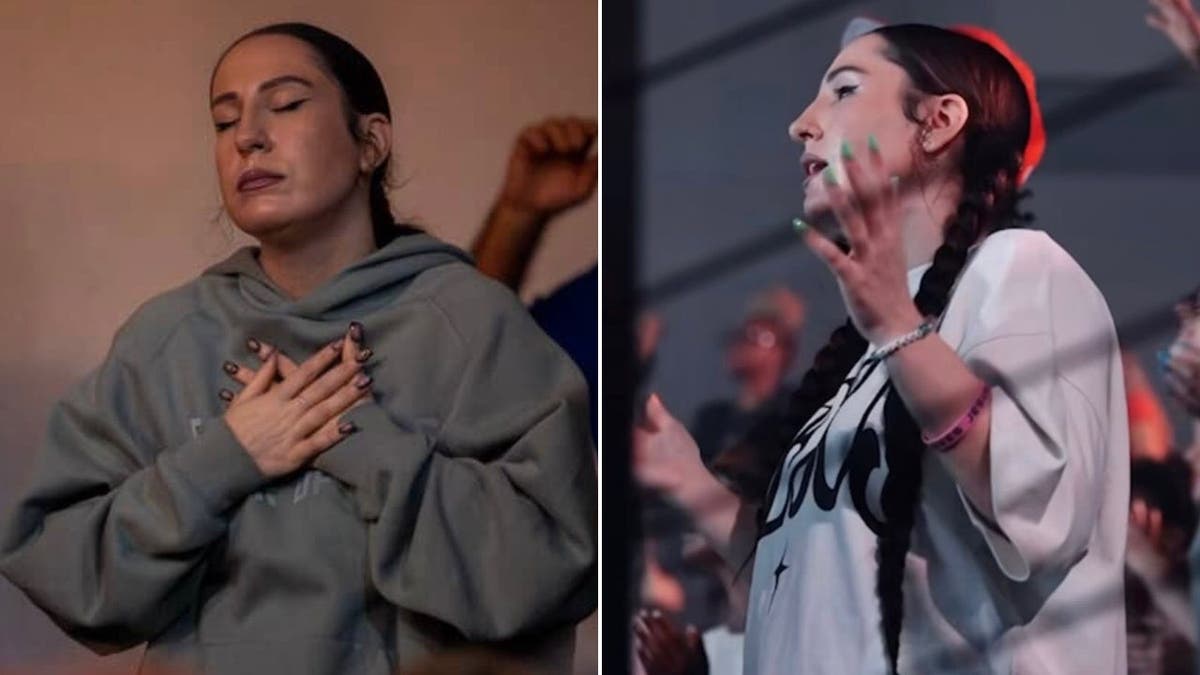 Hannah Hirsh holds her hands up during worship in church.
