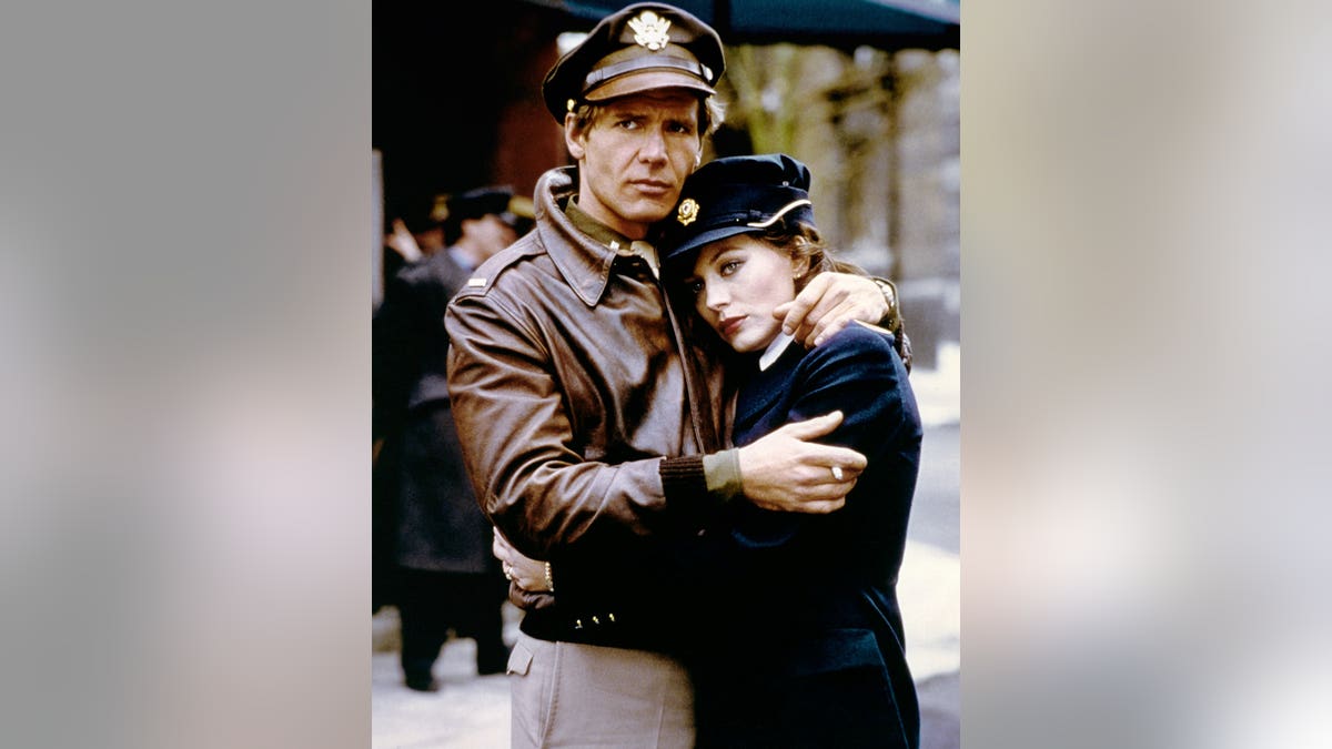Harrison Ford and Lesley-Anne Down stand together on a film set.