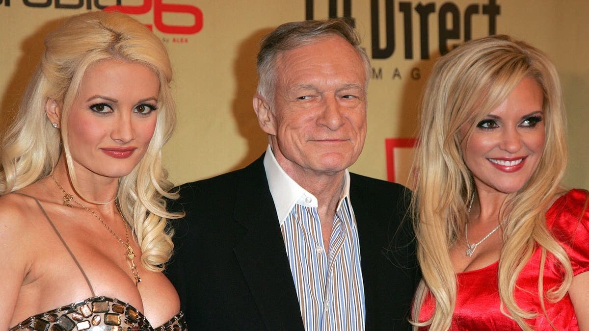 Holly Madison, Hugh Hefner and Bridget Marquardt pose at a holiday party.