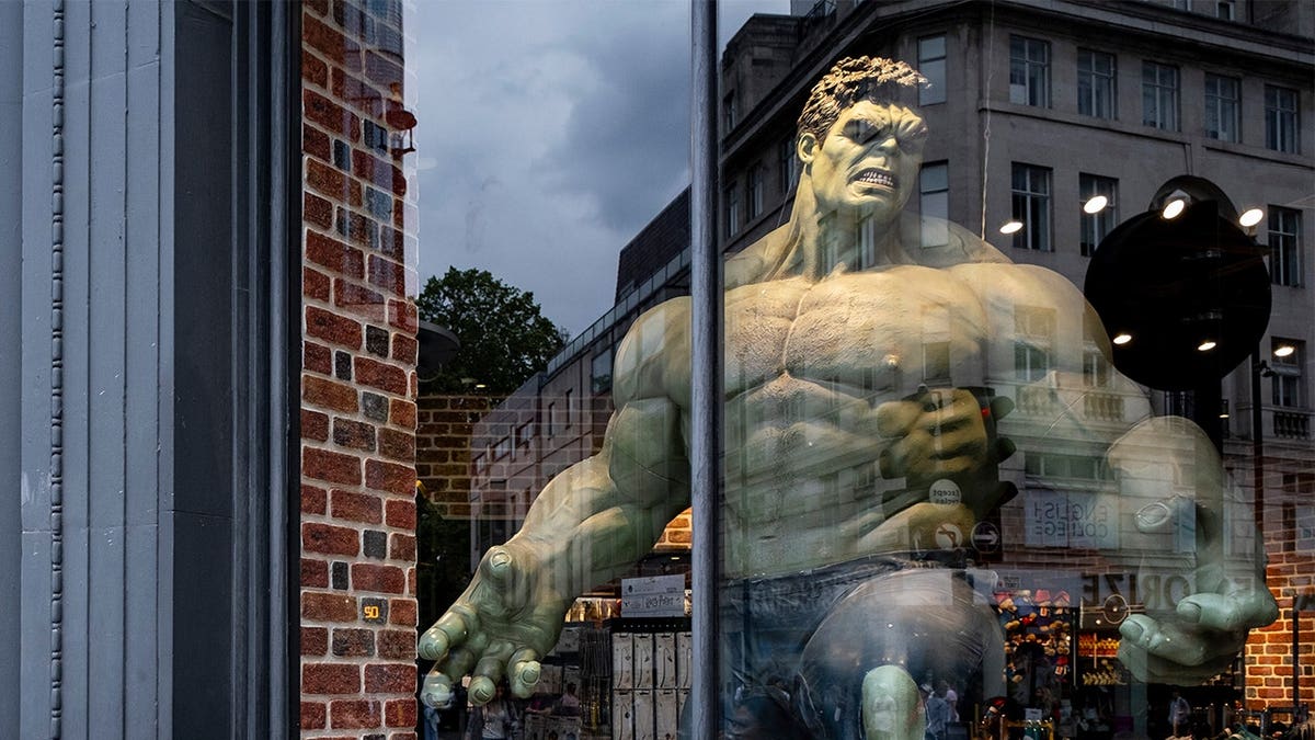 Shoppers pass the Millennia fantasy shop window displaying a large Hulk figure on Oxford Street in London.