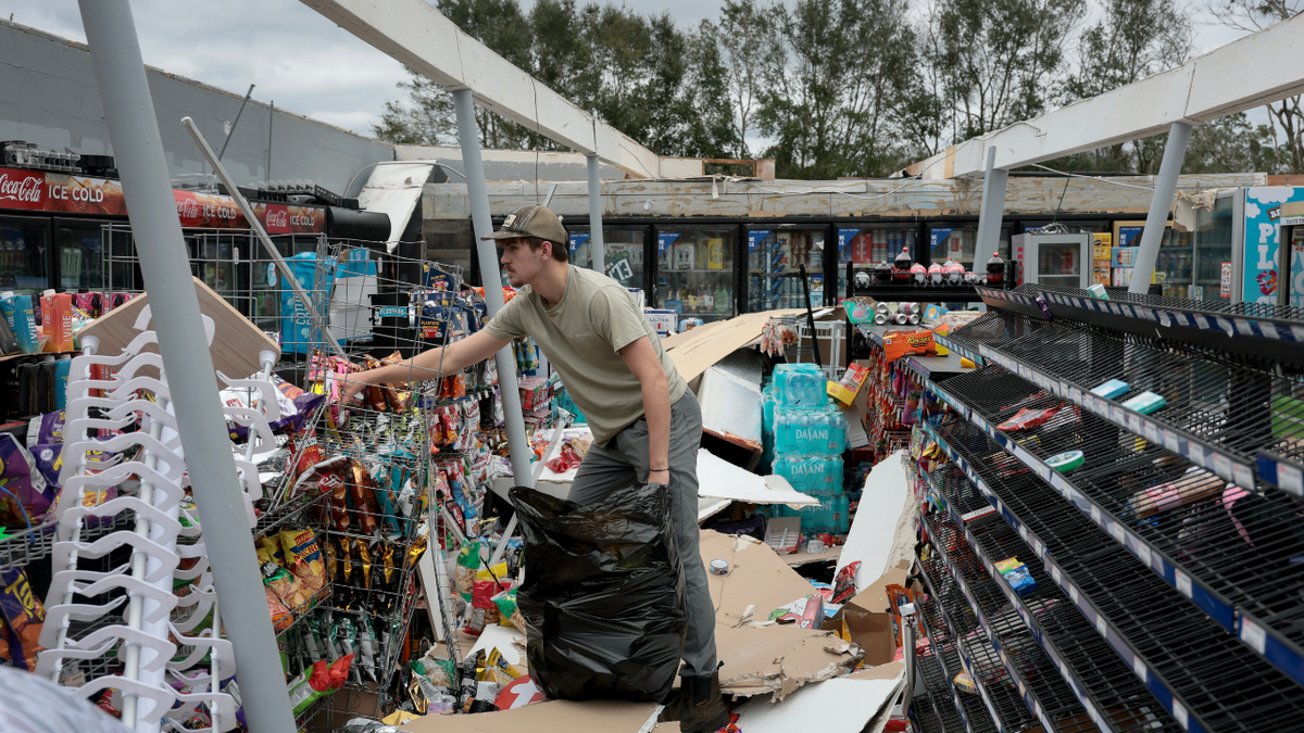 Un hombre limpia una tienda tras el paso del huracán Isaias por la zona el 10 de octubre de 2026, en Milton ( Florida).
