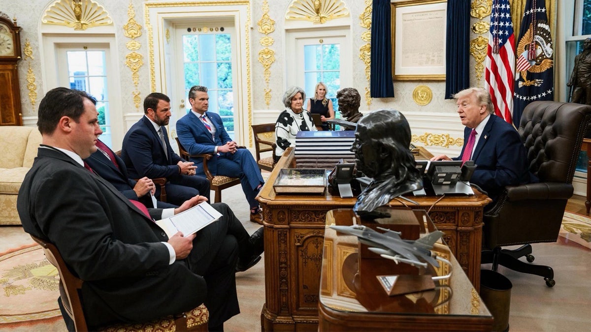 Cabinet members and aides sit around President Trump's desk at the Oval Office